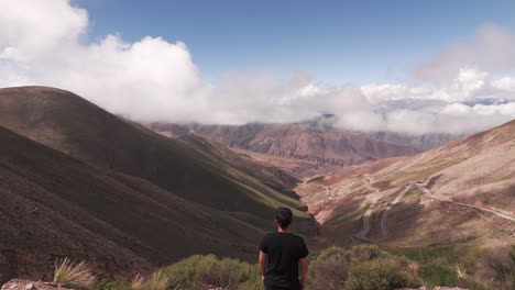 Aerial-view-of-man-standing-on-hill-admiring-the-landscape-of-Route-52,-Lipan-Slope