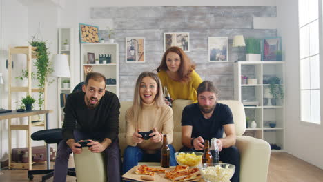 grupo de amigos relajándose juntos en la sala de estar jugando videojuegos