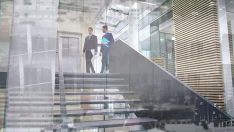 animation of office building over businessmen talking in modern office