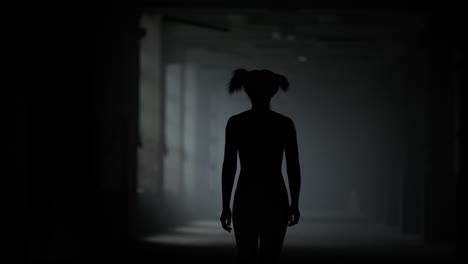 female athlete walking in corridor. sporty woman going in dark loft building