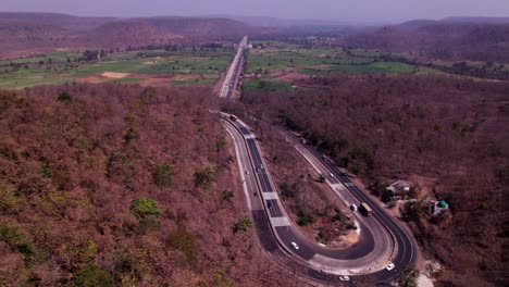 curved road with hill mountains and crop fields lands at siluwa, ramanpur, hulki, madhya pradesh, india. day time, semi orbit, drone shot, 4k.
