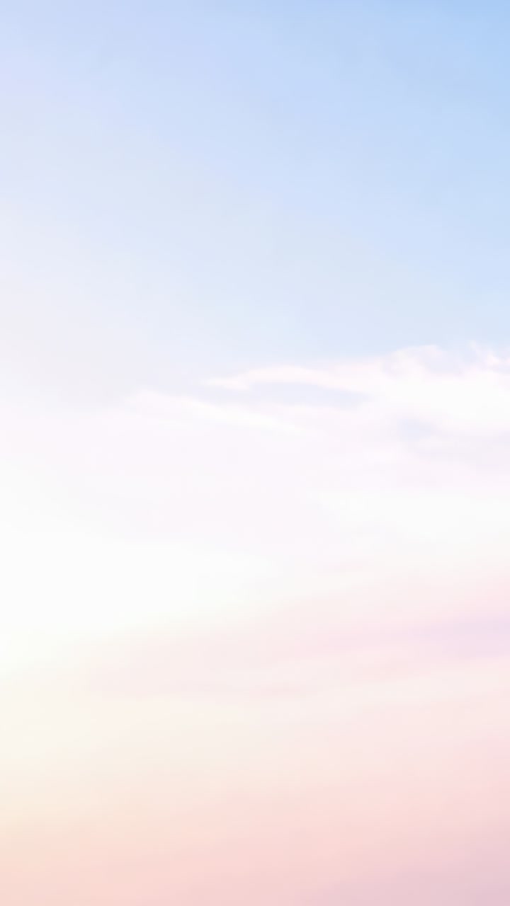 Vertical video: Showing sky brightening in vertical frame, blue-pink gradient, thin clouds drifting