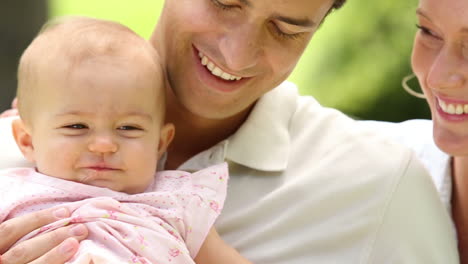 padres felices con su niña en el parque