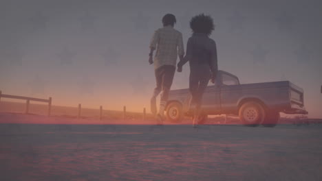 animación de la bandera de américa sobre una feliz pareja diversa corriendo hacia el camión en la playa al atardecer