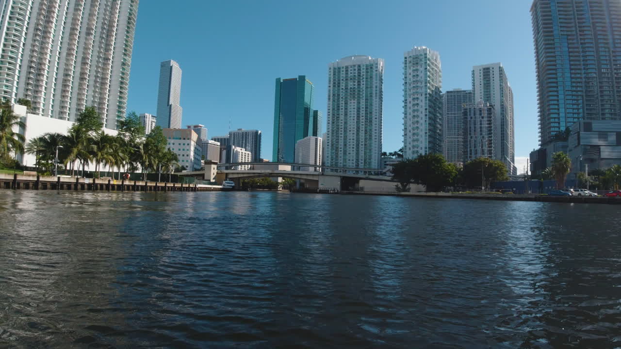 view from the bow of a small boat on the waterway in Miami Florida on a sunny day with tall buildings ahead