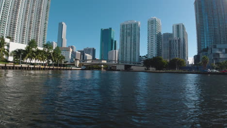 Vista-Desde-La-Proa-De-Un-Pequeño-Barco-En-El-Canal-De-Miami,-Florida,-En-Un-Día-Soleado-Con-Edificios-Altos-Delante