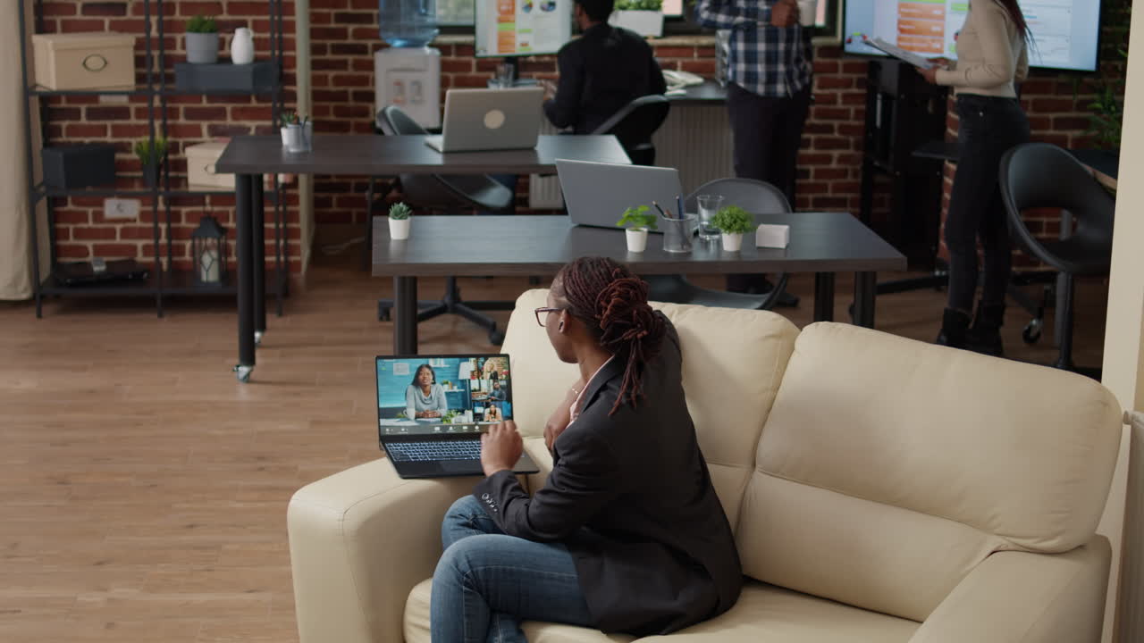 Female employee using remote videocall conference on laptop
