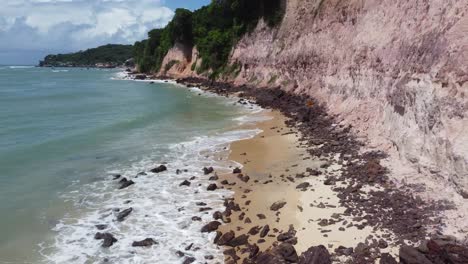 marea alta de acantilados al lado de la playa brasileña y cantidades poco profundas de playa para caminar