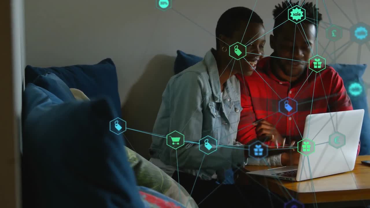 Animation of connected icons over african american couple talking and watching video on laptop