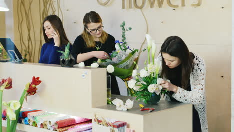 el personal de la floristería hace ramos de flores para la venta