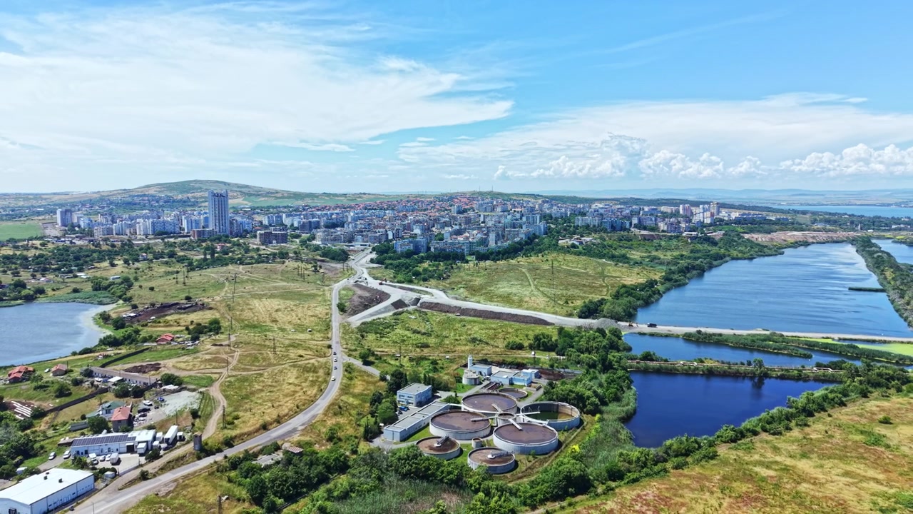 Vista di un paesaggio urbano che mostra edifici, acqua e aree verdi durante una giornata di sole in estate