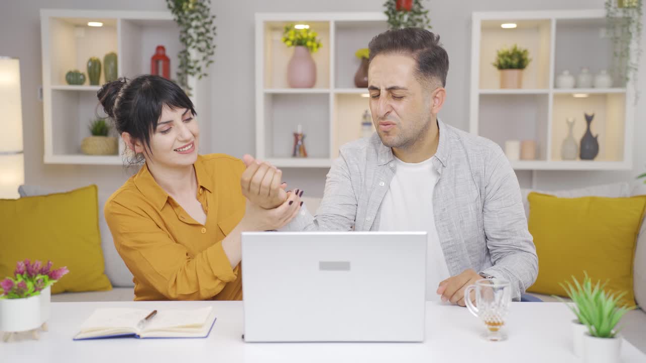 la muñeca de la pareja que trabaja en la computadora portátil es pesada.