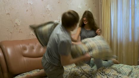 los niños pelean con las almohadas en el dormitorio.