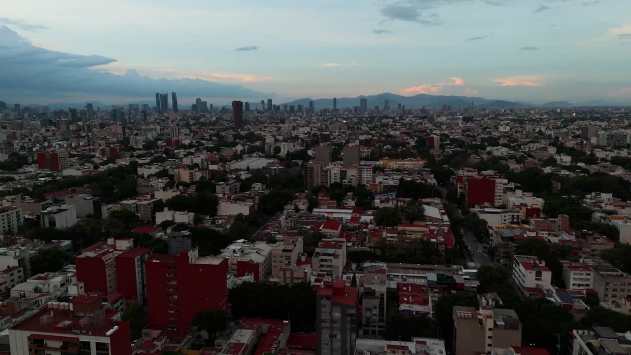 Aerial footage of Mexico City during a cloudy summer sunset, captured by a drone