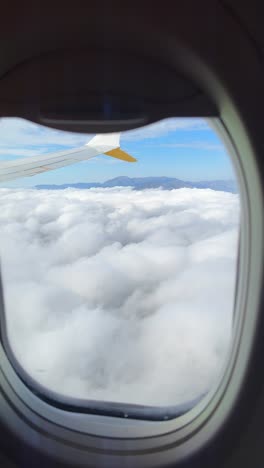vista de las nubes y las montañas por la ventana del avión