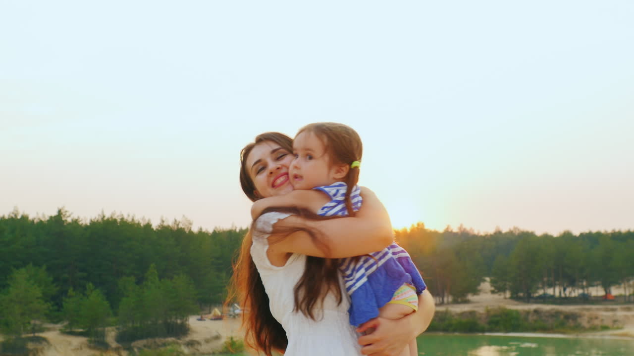 Mom Plays With Her Daughter Hugging And Turning It Into Sunset
