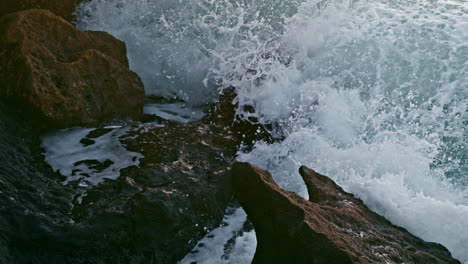 sea splashing crag nature at morning closeup. foamy water breaking over coast