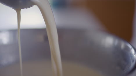 woman scooping batter with ladle close-up