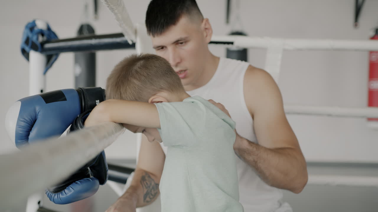 Boxing Coach Supporting a Young Boxer
