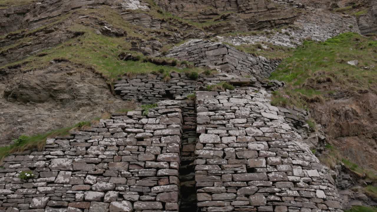 tilting shot revealing the stunning Whaligoe Steps with mast support at the harbour