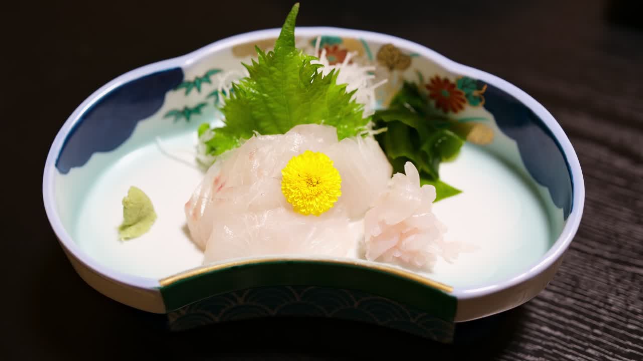 Piatto di sashimi di hirame giapponese con passera di mare fresca e guarnizioni tradizionali su ceramica