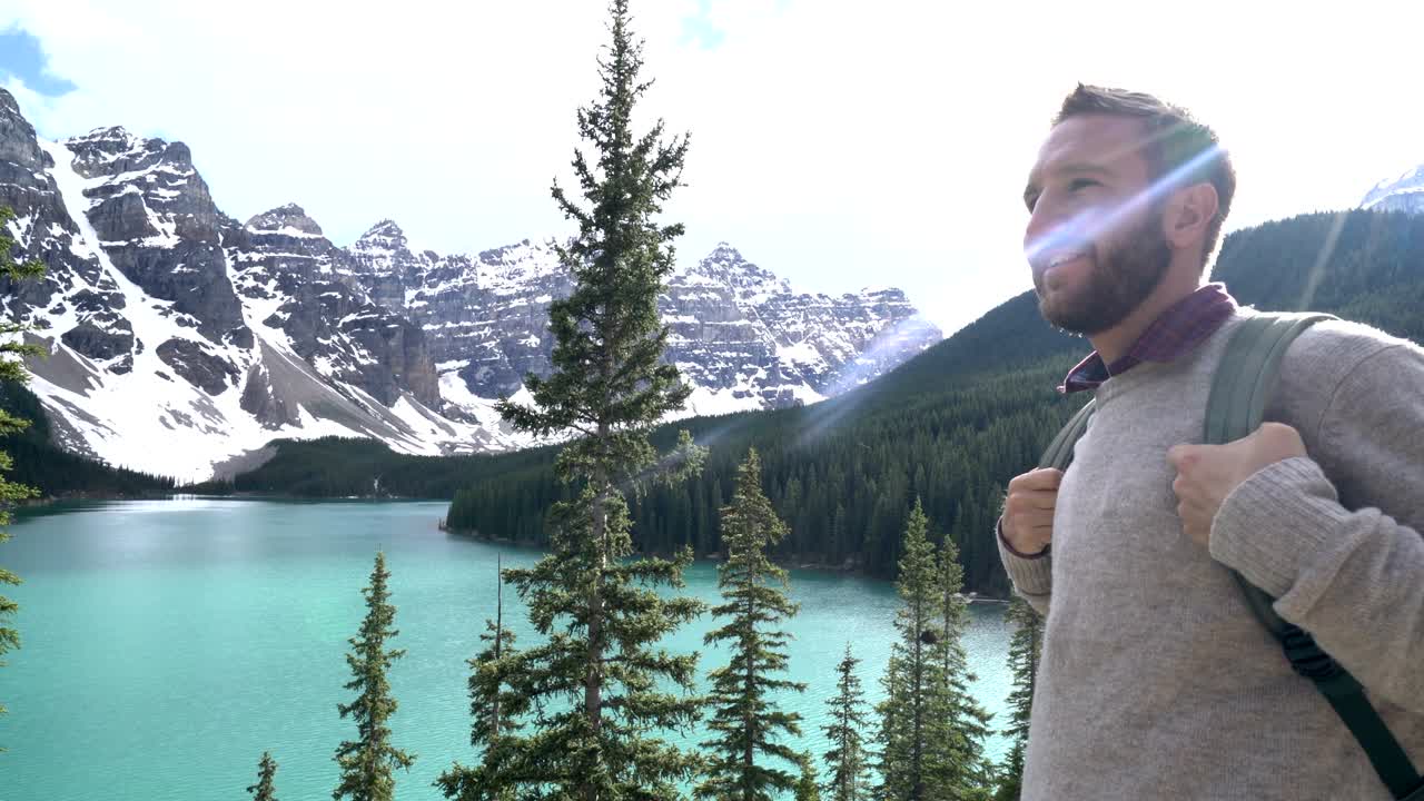 joven caminando mira el lago de montaña