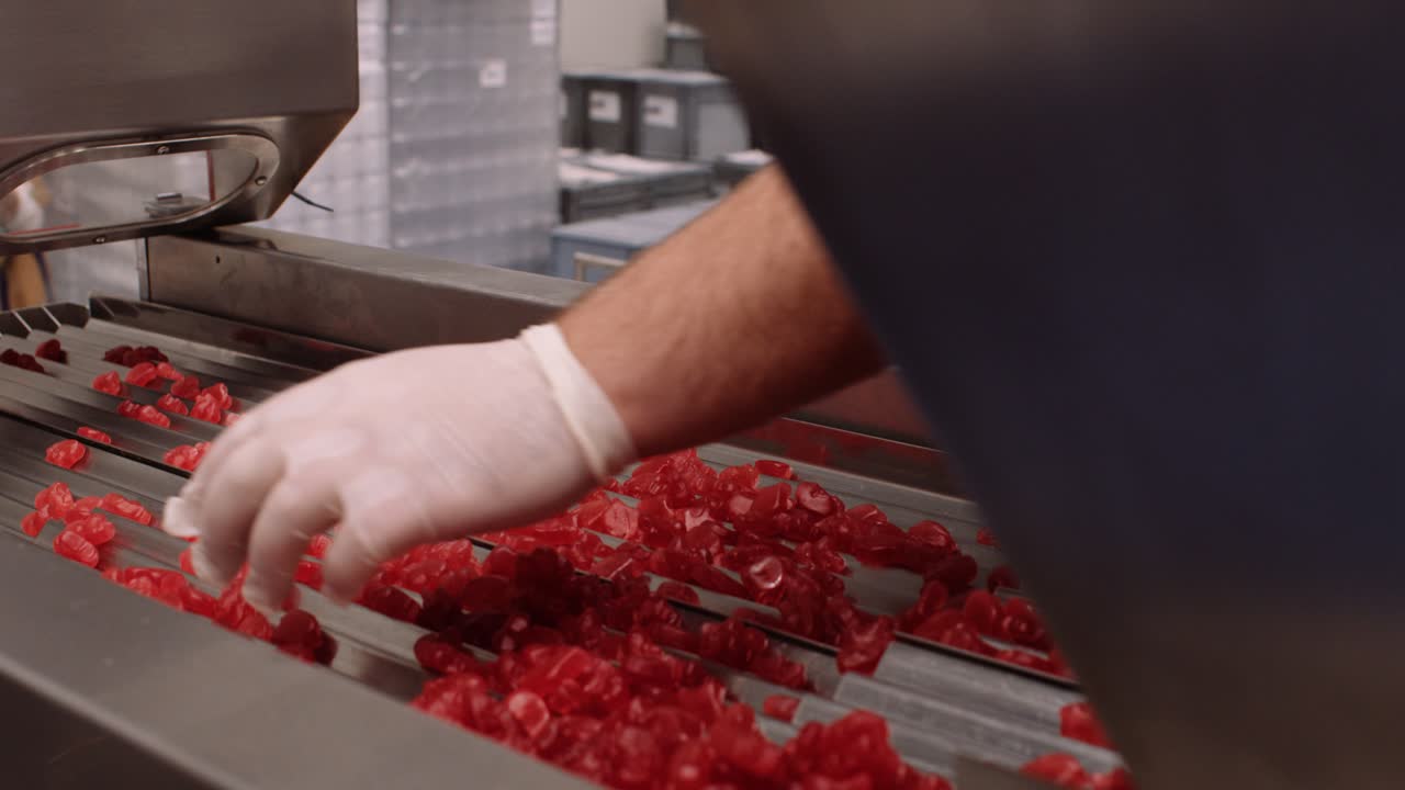 красные мультивитаминные жевательные добавки раскладывают по лоткам - нутрицевтическая промышленность