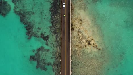 vista de pájaro del puente del coche sobre el agua turquesa en la isla tropical
