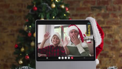 Feliz-Padre-E-Hijo-Saludando-En-Videollamada-En-Computadora,-Con-Adornos-Navideños-Y-árbol