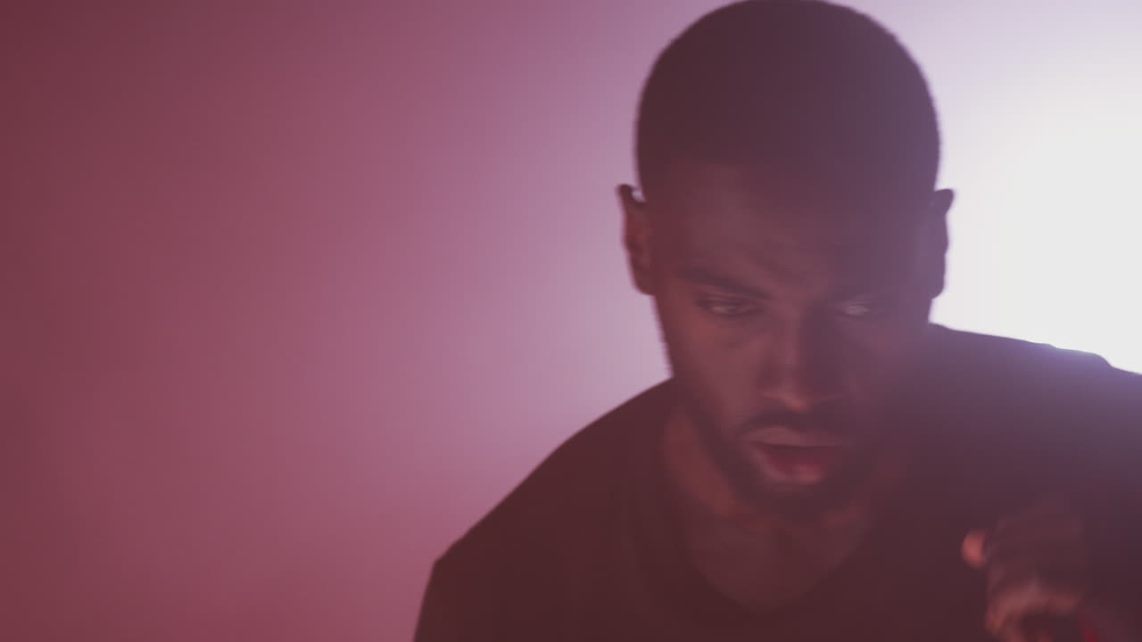 disparo retroiluminado dramático de un boxeador masculino en el gimnasio con envolturas en las manos entrenando