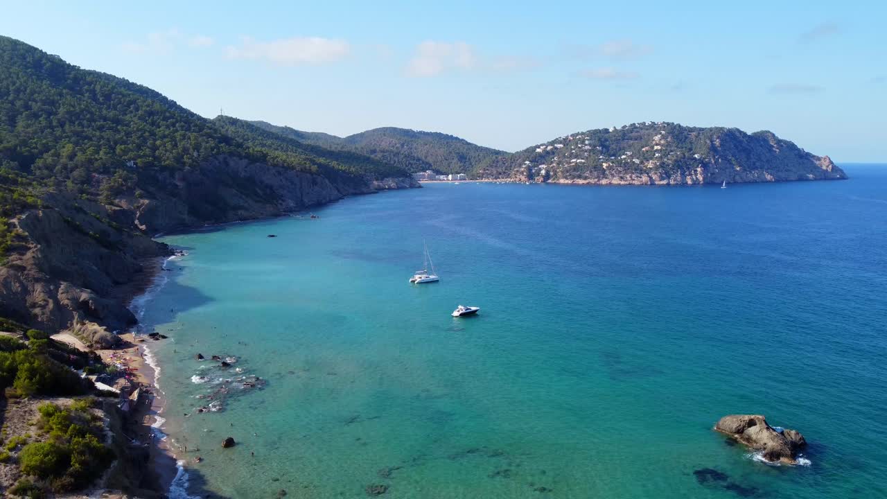 2 barcos frente a la playa del acantilado en aguas turquesas