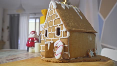 Dolly-in-zoom-shot-of-homemade-gingerbread-cookies-christmas-house,-festive-blurry-background-4K