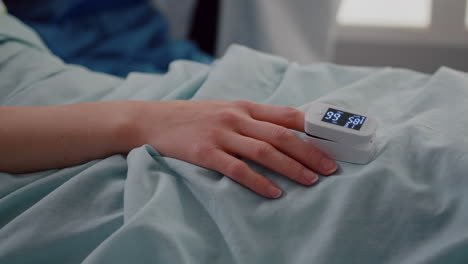 close up of sick woman resting in bed in hospital ward