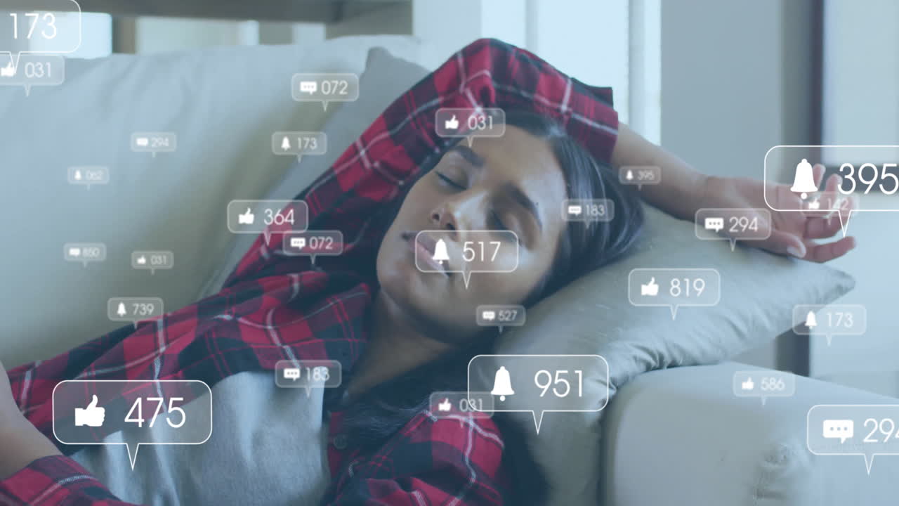 Animation of media icons over biracial woman sleeping on couch