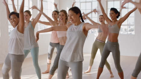 group of multi ethnic women learning dance moves enjoying fitness instructor teaching dancing choreography showing routine having fun in studio