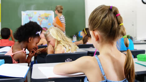 schoolgirl doing homework in classroom