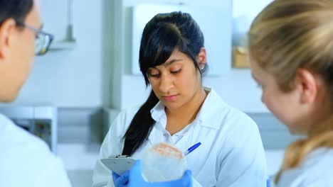 mujer científica escribiendo en un bloc de notas 4k