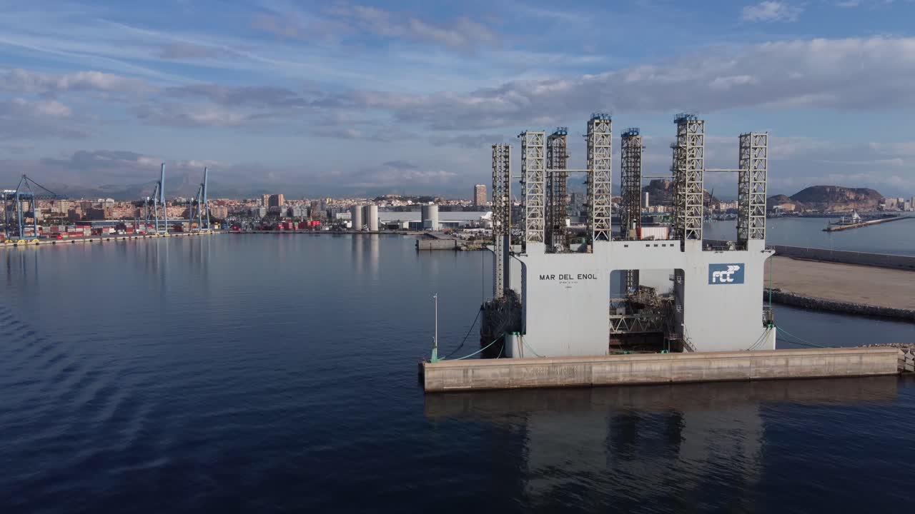 Aerial approach of The "Mar del Enol", floating dock for maritime construction projects, with the city of Alicante in the background