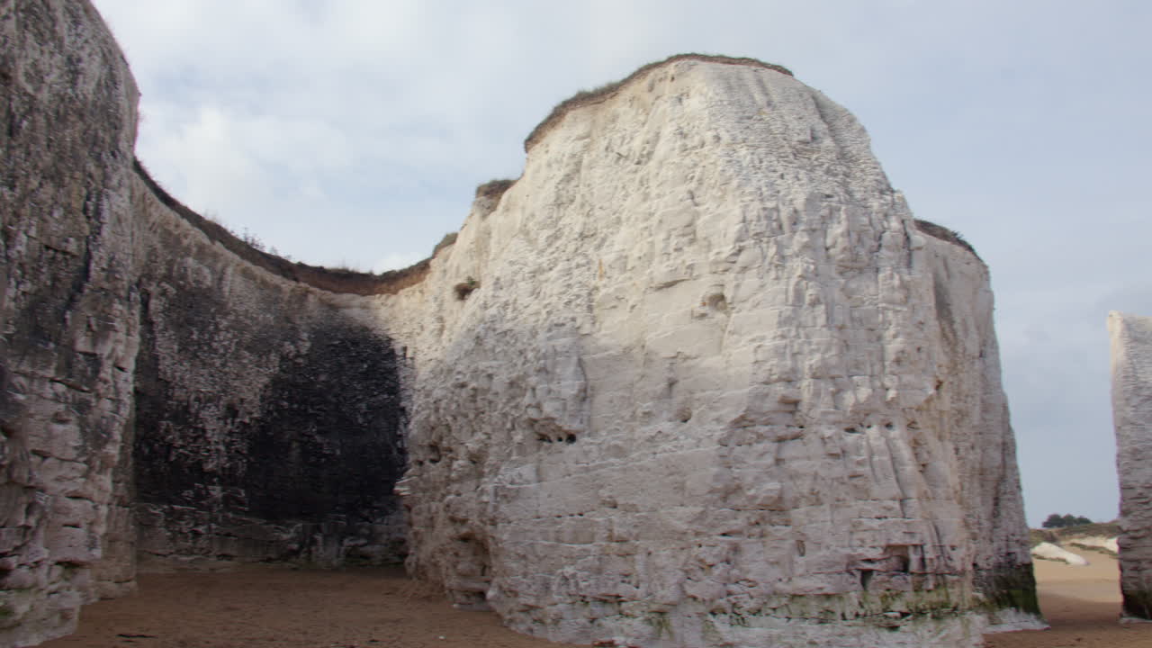 Panorámica de derecha a izquierda de acantilados y farallones de tiza blancos en la playa de Botany Bay con marea baja. En Marine Drive, Broadstairs.