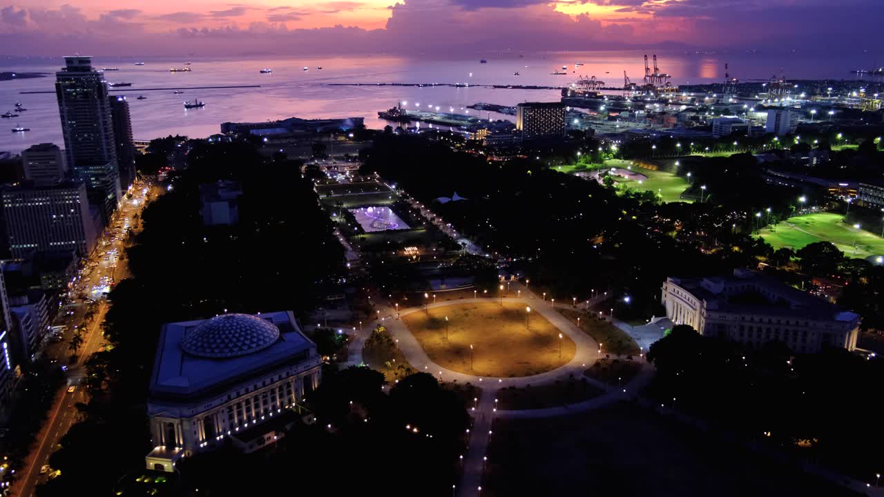 Aerial view of Rizal Luneta Park at night with lights on water fountain during beautiful sunset in capital city of Manila Philippines