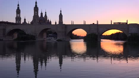 a classic and beautiful stone bridge in zaragoza spain with cathedral background