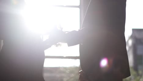 slow motion shot of wine glasses being passed with a bottle being opened