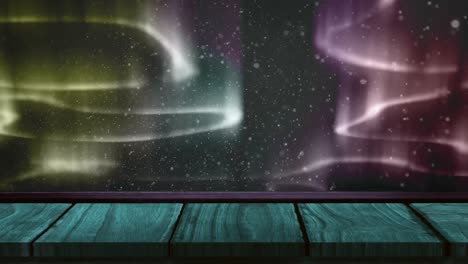 animación digital de nieve cayendo sobre una superficie de madera contra rastros de luz coloridos en un fondo negro