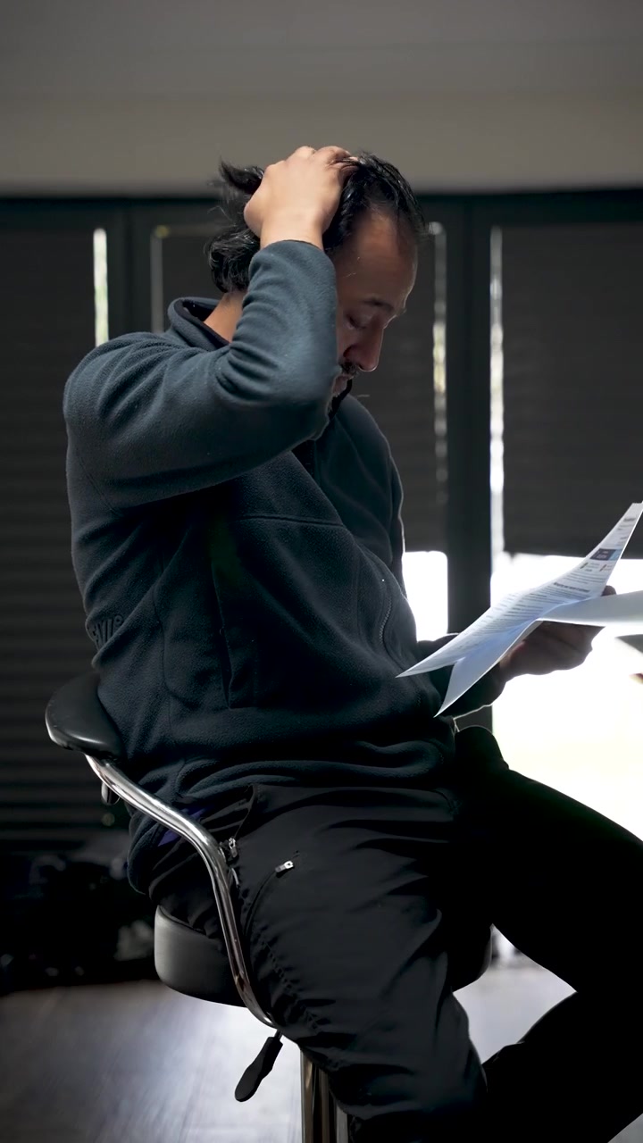 A South Asian man is shown in a state of stress and anxiety. vertical video