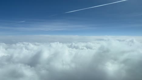 vista aérea del cielo desde una cabina de jet mientras sobrevuela nubes blancas durante el nivel de crucero