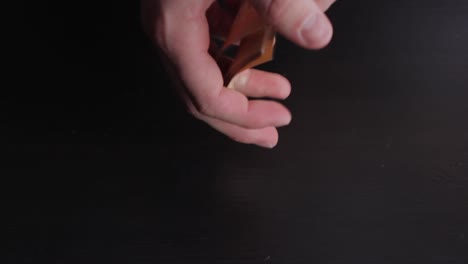 top down view of hands showing many 50 euros banknotes, dark black background, static