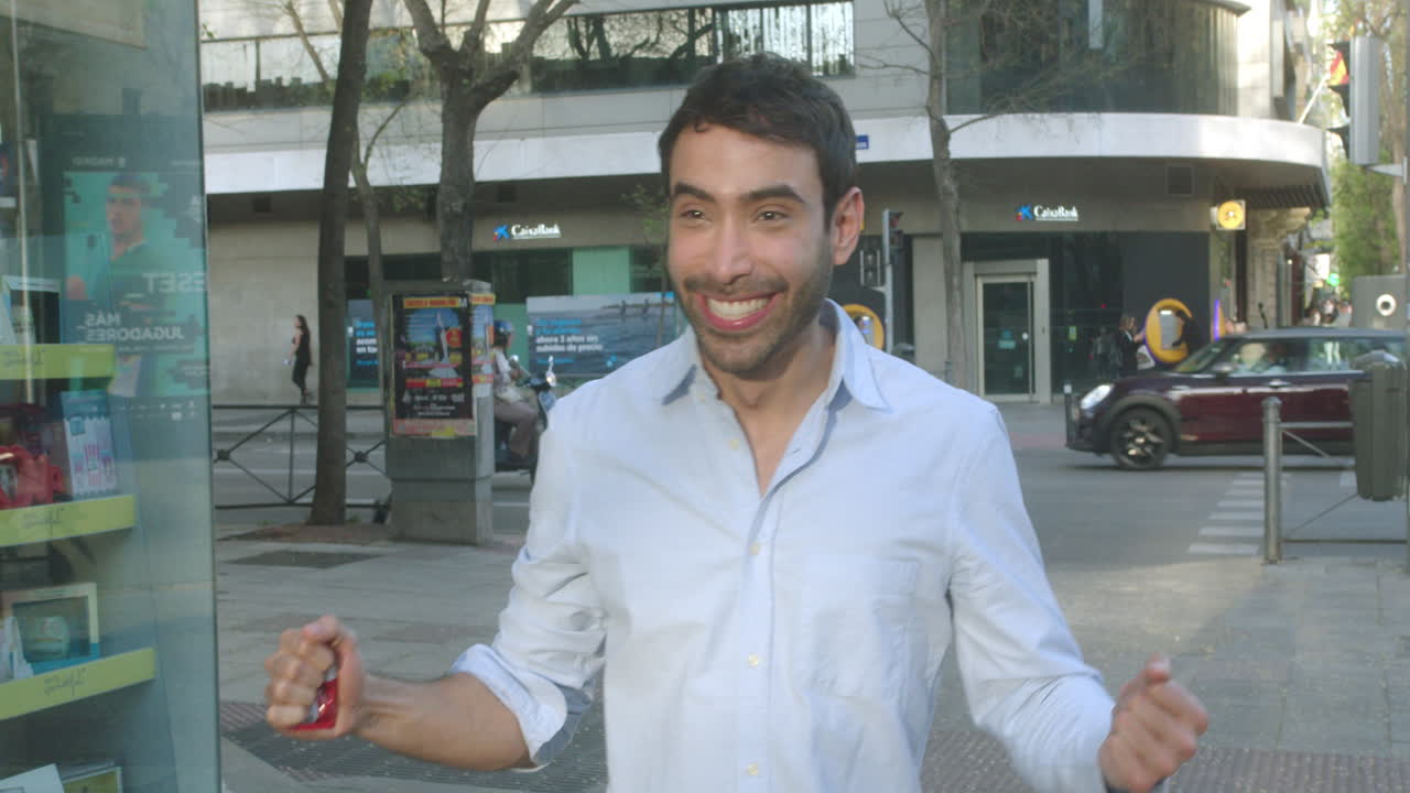 hermosa foto de un joven latino comiendo dulces en una calle de madrid por la tarde en cámara lenta
