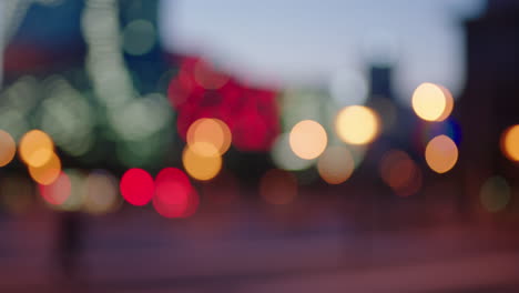 Hermosas-Luces-Urbanas-De-La-Ciudad-Bokeh-Desenfocado-Con-Gente-Caminando-En-Círculos-De-Semáforo-Nocturno