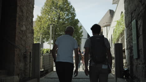 two man walking into the ljubljana castle yard through the stone arch