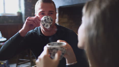 Close-Up-Of-Couple-Sitting-At-Table-Drinking-Tea-In-Traditional-English-Holiday-Hotel